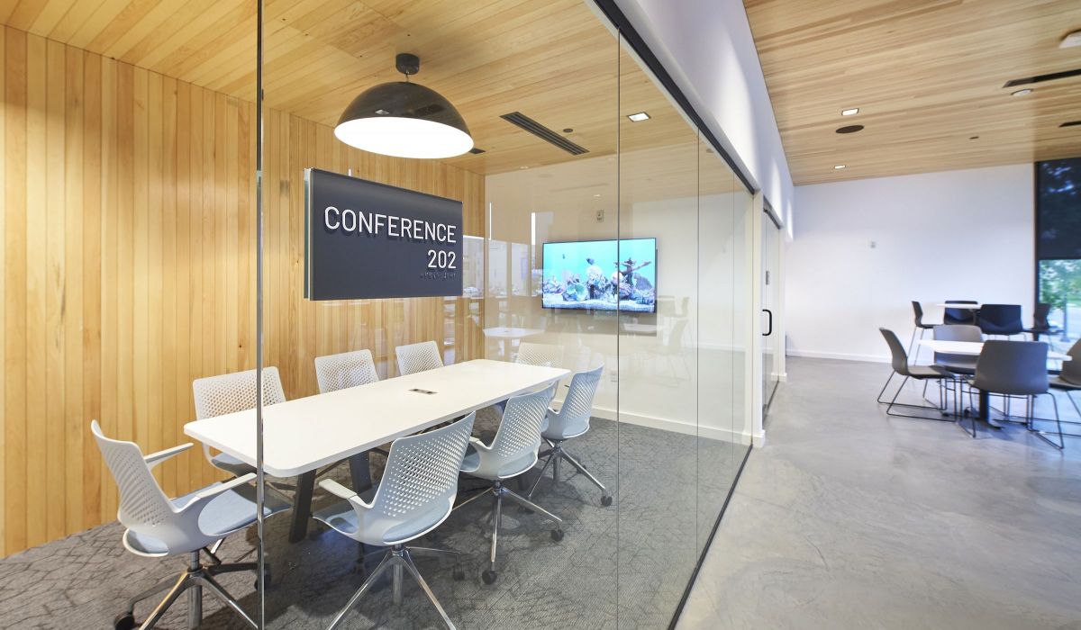 Conference room at VERVE St. Louis with long white conference table, chairs surrounding it, and a flatscreen tv on the wall